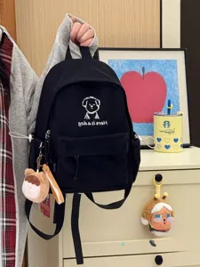 Close-up of black backpack detail with cute puppy print, side pockets and straps.