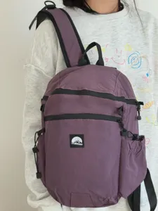 Sac à dos violet multifonctionnel avec grande capacité, fermetures éclair et poches latérales.