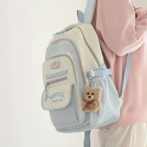 Dettaglio zaino azzurro chiaro con stelle, grazioso ciondolo ad orsetto e tasche pratiche.