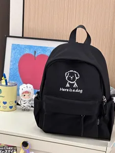 Detailed view of black canvas backpack with cute puppy embroidery and casual style.