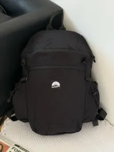 Vue détaillée de sac à dos de voyage léger noir, avec tissu durable et poches multiples.