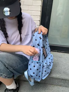 Vista dettagliata dello zaino azzurro a pois con tasca laterale e porta carte trasparente.