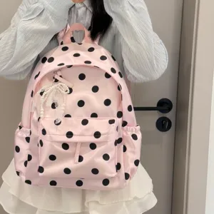 Detail shot of the cute pink polka dot backpack with a delicate pearl lace pendant strap.