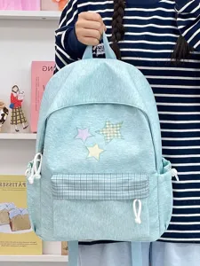 Gros plan détaillé du sac à dos bleu clair avec de jolis patchs d'étoiles et poche avant.