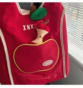 Mochila roja detalle manzana bonita con colgante de peluche corazón de manzana y bolsillo.