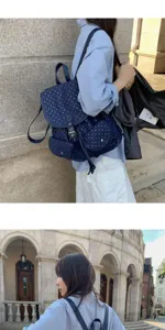 Detail view of the navy blue star pattern casual college style backpack in outdoor scene.