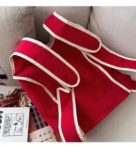 Vista detallada de la mochila estilo chaleco rojo con ribete blanco para uso diario.