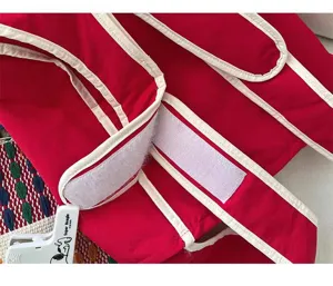Vista detallada de mochila chaleco roja con ribete blanco limpio y correas de velcro seguras.