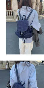 Detailed view of the navy blue polka dot backpack, showing strap and pocket style details.