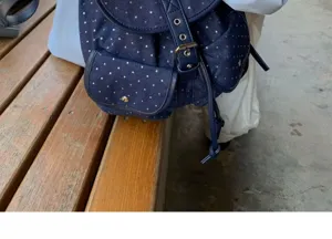 Denim backpack detail featuring charming silver stars, compact front pocket and metal hardware.