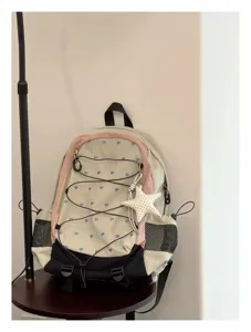 Detailansicht des stylischen Outdoor-Rucksacks mit Herzmuster und süßem Sternenanhänger.