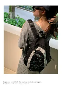 Detailed view of the stylish black and grey casual backpack with cute heart embroidery.