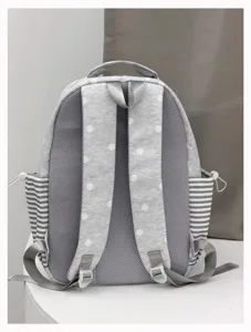 Detailed view of grey polka dot backpack back panel, breathable mesh, and striped side pockets.