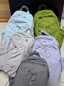 Detailed shot of multi-color casual pleated backpacks showcasing textured fabric and drawstring.