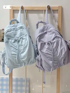 Detail view of stylish rucked lightweight backpacks in pastel blue and purple colors.