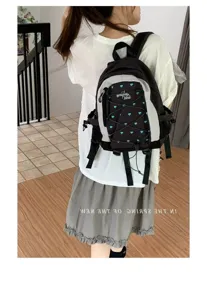 Detailed view of a trendy black and grey backpack with blue heart prints, ideal for daily commute.
