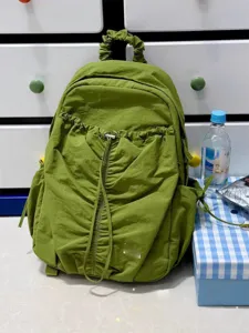 Green pleated backpack detail, lightweight travel daypack with drawstring design, casual college style.