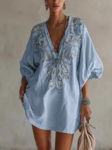 Vue détaillée de la robe en coton bleu clair col V avec broderie florale complexe.