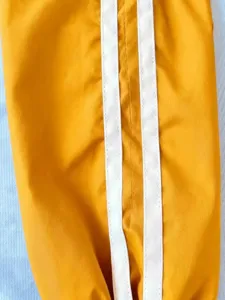 Close-up detail of yellow jacket sleeve featuring dual white parallel side stripes.