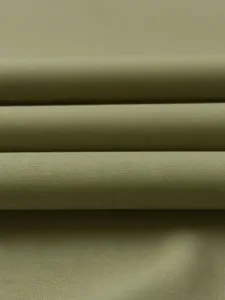Close-up fabric detail of olive green textile material, showing fine woven texture.