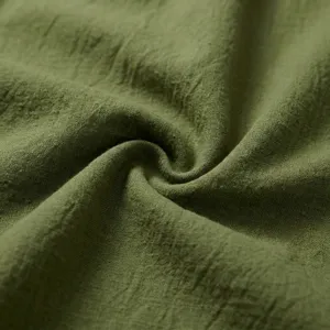 Primer plano detallado de tela de lino verde suave que muestra textura y pliegues naturales.