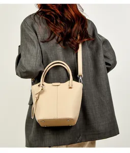 Detailopname van de beige lederen emmertas voor dames met een mooie korrelige textuur.