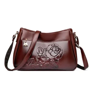 Vintage bruine dames leren schoudertas met in relief gedrukt rozenpatroon en elegante stijl.