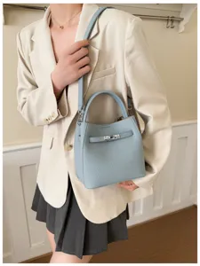 Elegant light blue leather bucket bag with top handle and shoulder strap for women daily use.