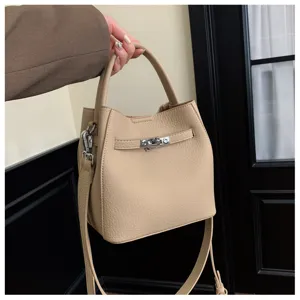 Chique beige leren emmertas met handvat en metalen sluiting. Stijlvolle schoudertas voor dames.