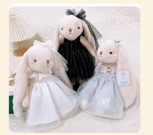 Detail view of cute lop-eared plush rabbit toys in elegant wedding dresses, soft and comforting.