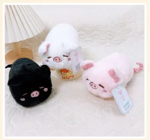 Nahaufnahme von süßen weichen Plüschschwein Squeeze-Spielzeugen in schwarz, weiß und rosa.