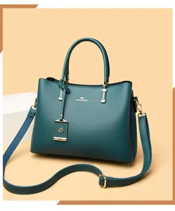 Dunkelgrüne große Damen Handtasche Schultertasche mit metallischen Beschlägen im Alltag.