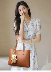 Stijlvolle bruine lederen shopper handtas voor dames, grote capaciteit tas met schattige berenhanger.