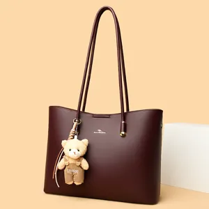 Bordeauxrode shopper voor dames, grote schoudertas met schattige berenhanger en lange hengsels.