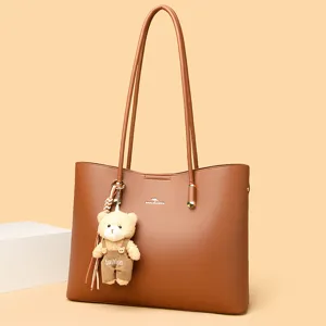 Elegante bruine handtas tote bag grote capaciteit PU lederen schoudertas met leuke berenhanger.