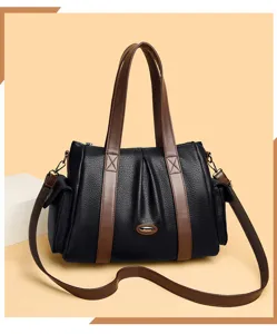 Detail view of stylish black women's handbag with brown handles and elegant texture.