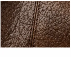 Close-up van de bruine lederen tassenstructuur met nauwkeurige dubbele stiksels.