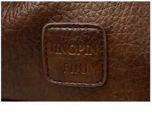 Detailopname van een bruine PU lederen dames handtas met een in reliëf gemaakte logo patch stijl.
