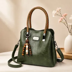 Retro donkergroene PU lederen dames handtas met gevlochten handvat, hanger en schouderband.