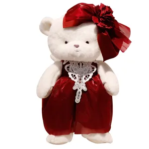 Cute white teddy bear plush toy wearing a red dress and bow for wedding gift and home decor.
