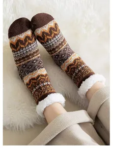 Gros plan détaillé de chaussettes d'hiver douillettes à motif marron et revers en peluche.