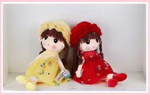 Vista dettagliata di simpatiche bambole di peluche con cappelli floreali e abiti, giocattolo.