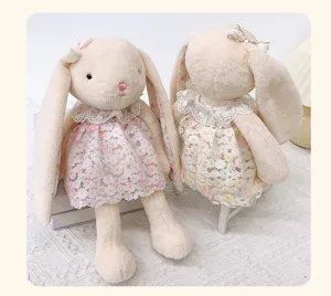 Detailed view of cute floppy ear bunny plush toy with lace floral dress, soft material.