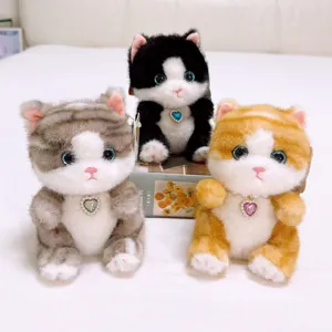 Cute plush cat keychain toy with sparkly blue eyes and heart pendant. Soft stuffed animal gift.