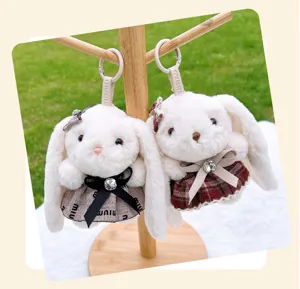 Detailed view of cute white plush rabbit keychain featuring stylish plaid skirt and bow.
