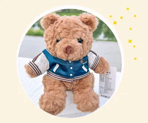 Detailed view of the cute brown plush teddy bear wearing a stylish blue and white jacket.