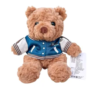 Cute teddy bear plush toy wearing a stylish blue varsity jacket, soft and cuddly gift.