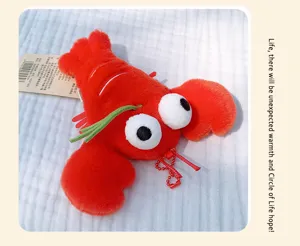 Close-up view of the red plush lobster keychain, showing soft fabric and funny design.