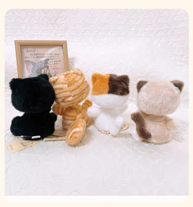 Vista detallada de cuatro adorables gatos de peluche de varios colores con un portafotos.