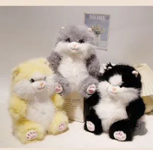 Primo piano di simpatici giocattoli di peluche di gatto in visone soffice in giallo, grigio e nero.